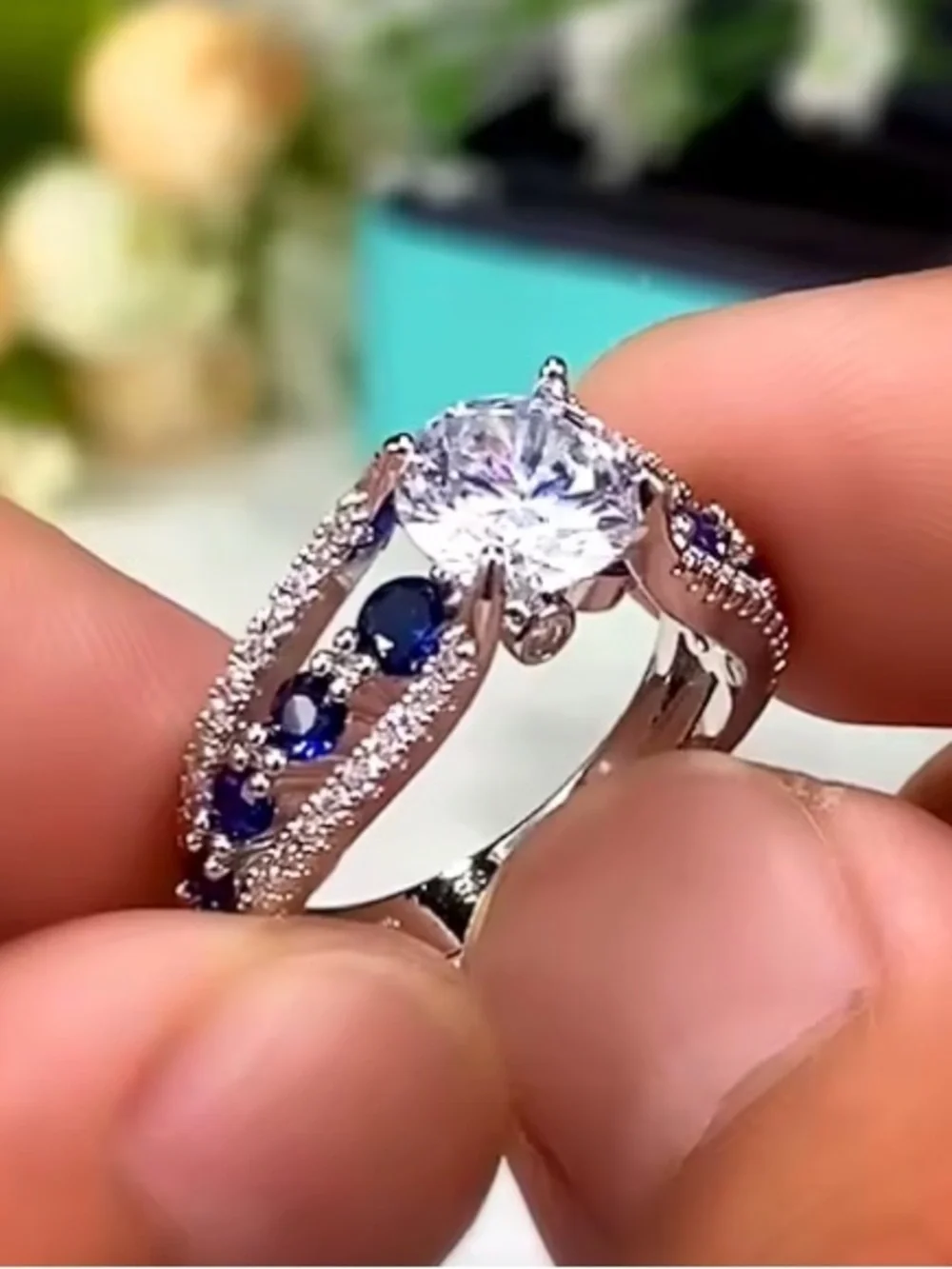 Silver Ring with Deep Blue Stones and Clear Center Gem.